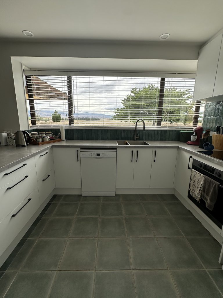 Quality kitchen install with white cupboards, built-in oven, and modern splashback fitted by qualified joiner